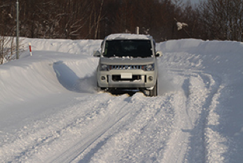 雪道を走る白いクルマ