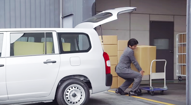スーツのビジネスマンが車に荷物を積み込んでいる風景
